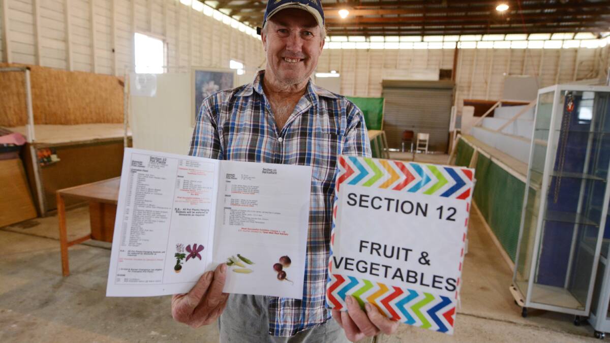 Taree Show helper, Trevor Maurer with schedules for this weekend's show. The show opens Friday with a family fun day and continues on Saturday and Sunday.