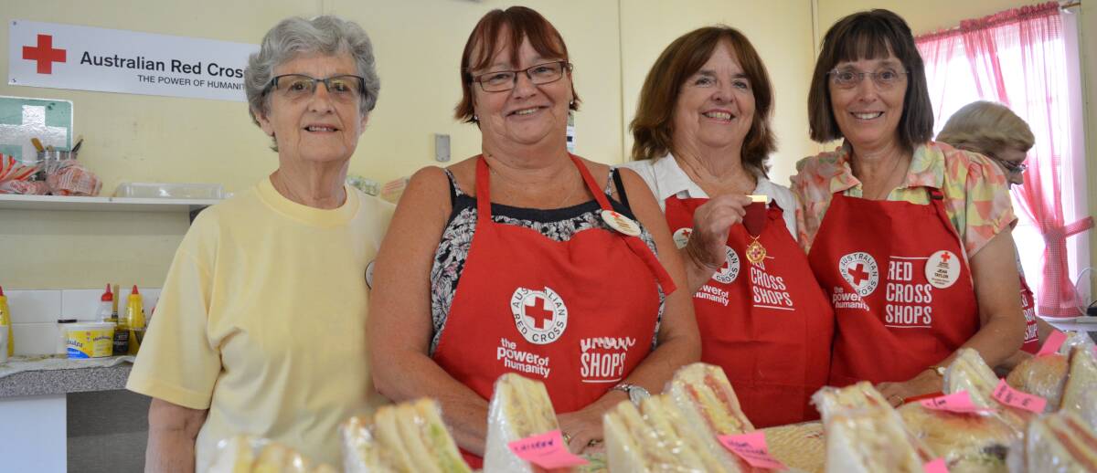 Service with a smile: Helen Parsons, Jennie Smith, Norma Knox (holding her Outstanding Award medal) and Jean Taylor during Thursday's store sale. 