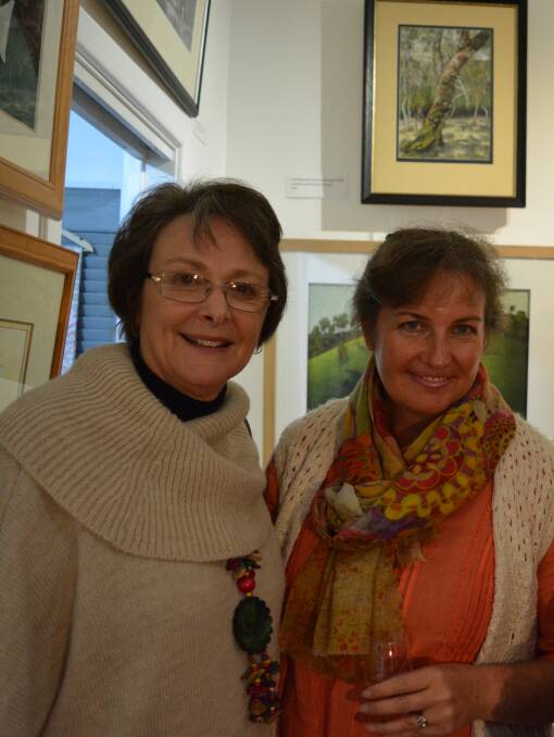 Kathy Leimgruber enjoys paintings and pottery at the Barrington Arts Gallery and Studio opening with Deb Walker.
