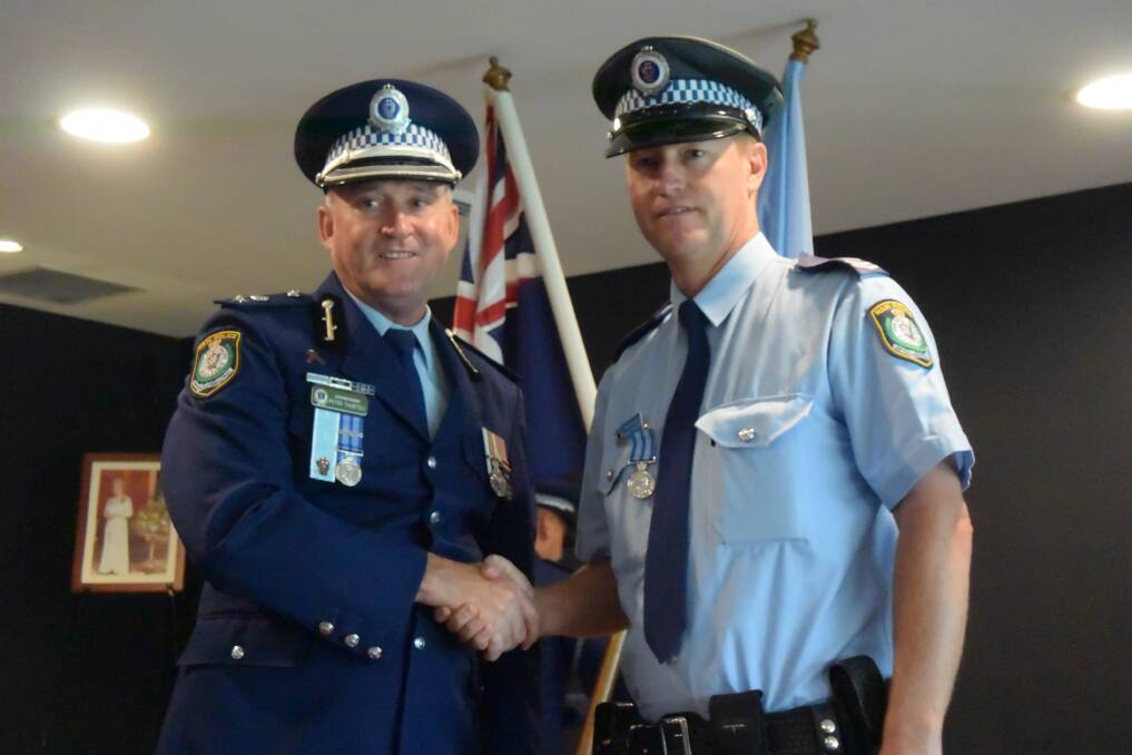 Manning Great Lakes superintendent Peter Thurtell presents the New South Wales Police Medal to Senior Constable Shaun Forrester. Picture: Laura Polson