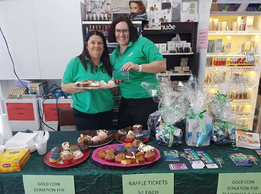 Yum yum: Gloucester Pharmacy staff Bernnie Brown and Lee-Anne Gutteridge offer customers treats for a good cause. Photo: Supplied