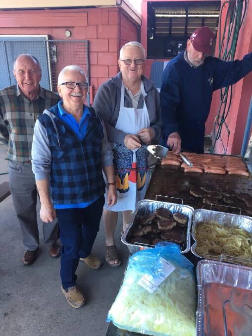 Members of Gloucester Probus get to work cooking the barbecue at the Gloucester Bowling Club. Photo. Supplied