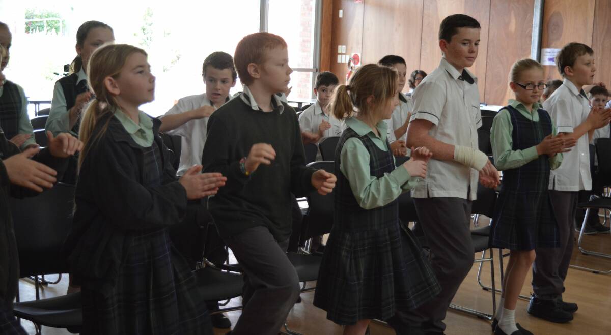 Creating their own sound: St Joseph's Primary School students stomp their feet and clap their hands to make their own music as directed by the Craven Creek Musicians. Picture: Anne Keen