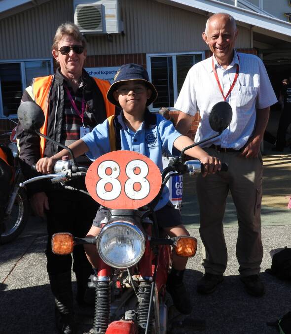 Checking out the ride: Tiko Samson gets to sit on one of the postie bikes after the breakfast to see what it's like to ride. Each year the Dash raises more than $100,000 for children in need across regional NSW. Picture: Supplied