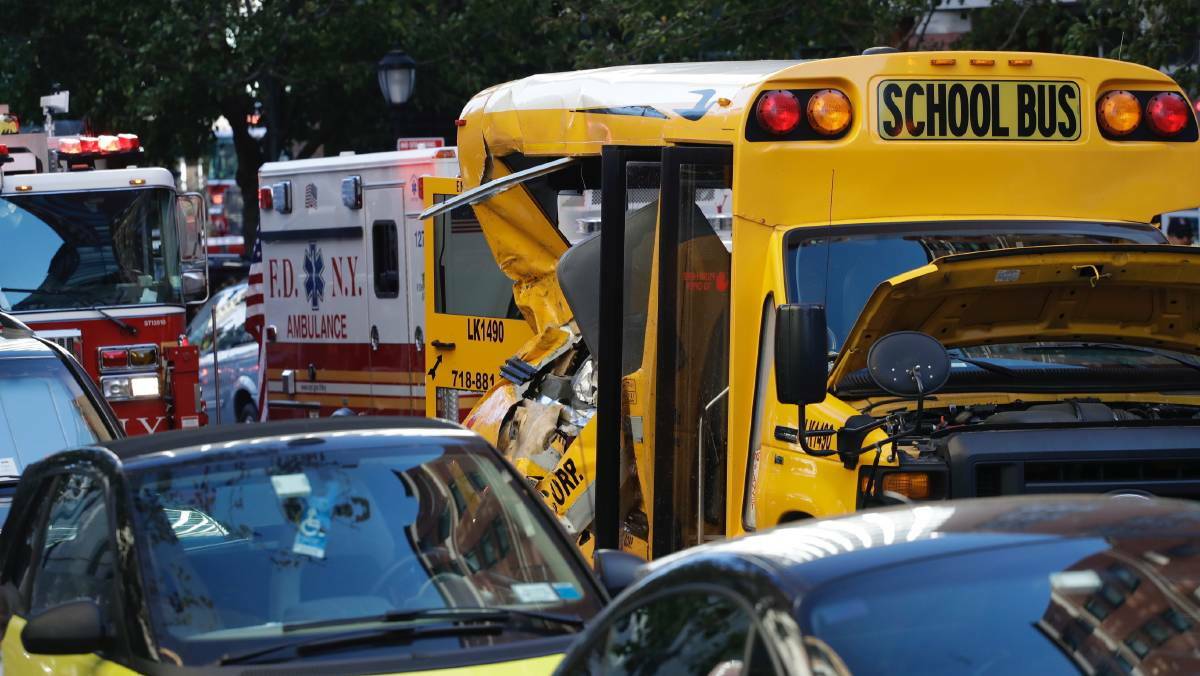 Some people were being treated for injuries near a mangled school bus. Photo: AP

