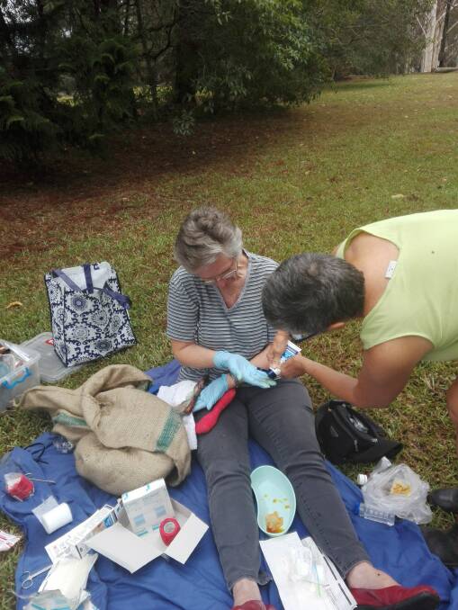 FAWNA president Meredith Ryan and local resident Deirdre Kerr treating a wallaby burned on the feet, paws and muzzle in the Pappinbarra fires.