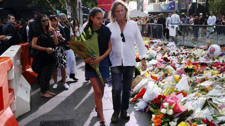 Tributes: Tori Johnson's father Ken and sister at the Martin Place memorial. Photo: James Brickwood