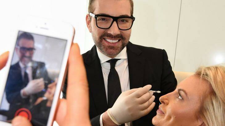 Snapchatting cosmetic surgeon Dr Kourosh Tavakoli with a staff member. Photo: Peter Rae
