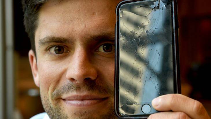 Flynn O'Byrne-Inglis, with his smashed iPhone, has had to replace several smartphones because of theft or damage. Photo: Steven Siewert