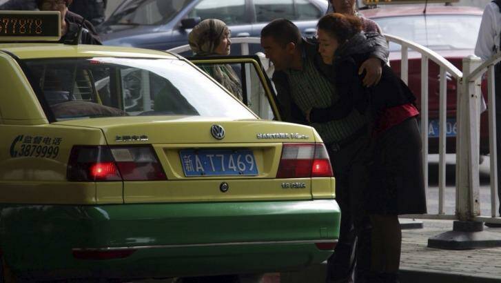 Ilham Tohti's wife Guzaili Nu'er is helped into a taxi after the verdict. Photo: Sanghee Liu
