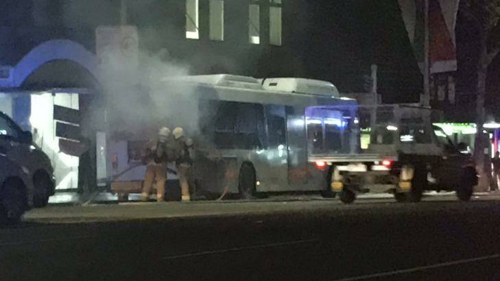 Firefighters extinguish a fire on a bus in George Street, Sydney, on Thursday night. Photo: Jim Cook