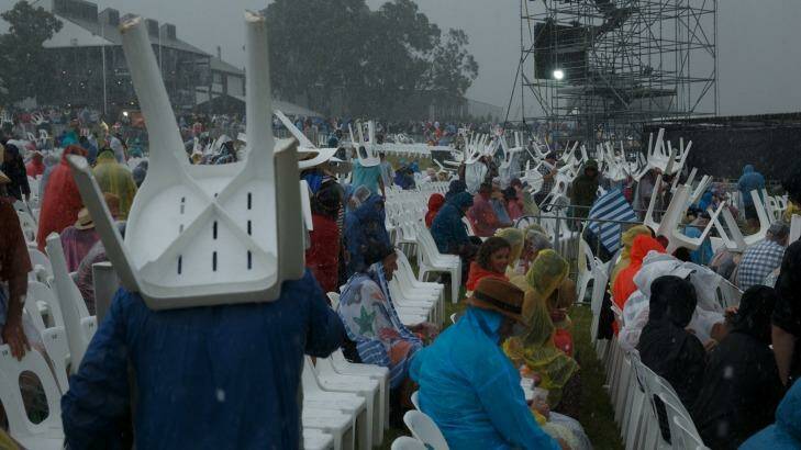 Concert-goers used the lawn chairs as shields against the hailstones.  Photo: Max Mason-Hubers