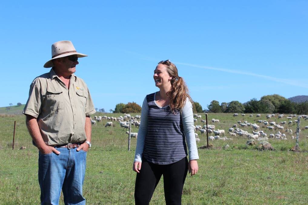 Farmer George Hamilton and daughter Madie enjoy the sunshine on their property near Meroo as some of the sheep they farm graze in the background.