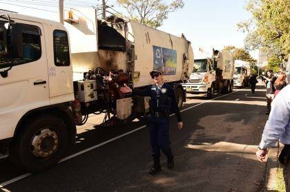 Police guide Blacktown garbage trucks during a protest over Struggle Street. Photo: Nick Moir