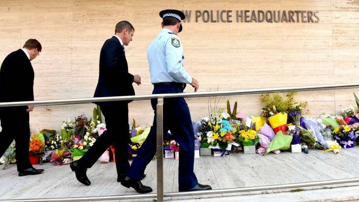 Premier Mike Baird walks past the many floral tributes left for  NSW Police accountant Curtis Cheng outside Parramatta Police headquarters.
 Photo: Steven Siewert