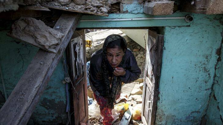 An earthquake survivor visits her collapsed house in Sankhu, on the outskirts of Kathmandu, Nepal on Tuesday. Photo: Athit Perawongmetha
