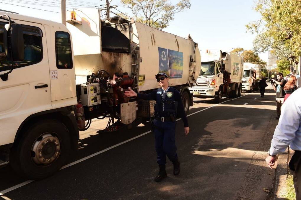 Police guide Blacktown garbage trucks during a protest over Struggle Street. Photo: Nick Moir