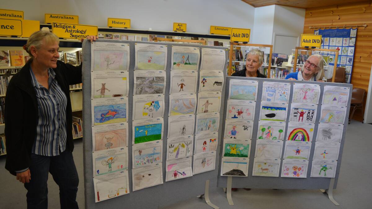 Librarian Cathy Devereux with judges Pippa Robinson and Patsy Murrell and some of the entries in the Book Week drawing competition.