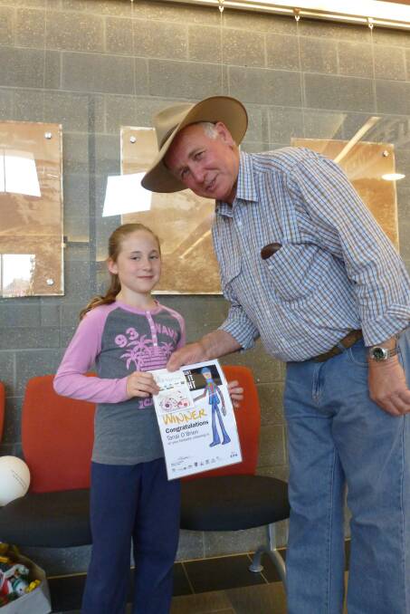 Tanai O’Brien is presented with an award by mayor John Rosenbaum for her colouring-in. 