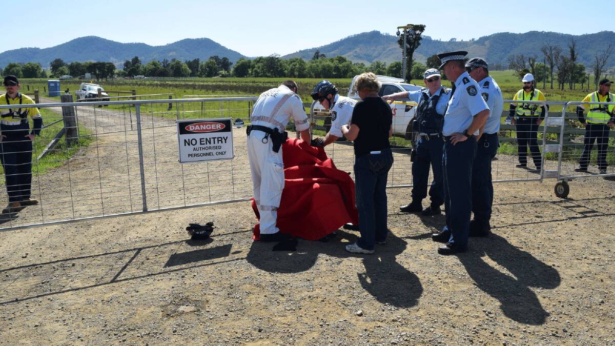 Police Rescue cut free Marnie Johnson after she 'locked on' to the gate accessing AGL's compound on Fairbairns Lane.