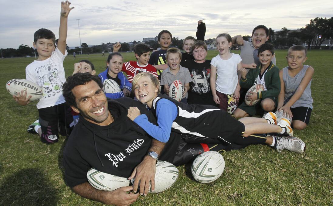 Port Kembla rugby league captain-coach Mark Simon, with his son Taj, and other members of the Under 9 team he coached in 2013. Simon only remembers copping a racial taunt once on the footy field but understands why Sydney Swans star Adam Goodes is feeling the heat. Picture: DAVE TEASE