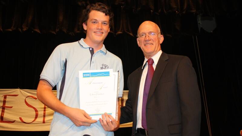 Ethan Hamilton receives the Defence Force Award from deputy principal Mike King.