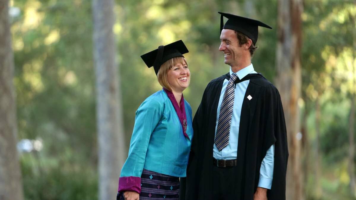 Happy grads: Jennifer Bates, in traditional Bhutanese dress, and Jordi Bates on the day they received postgraduate degrees at the University of Newcastle.