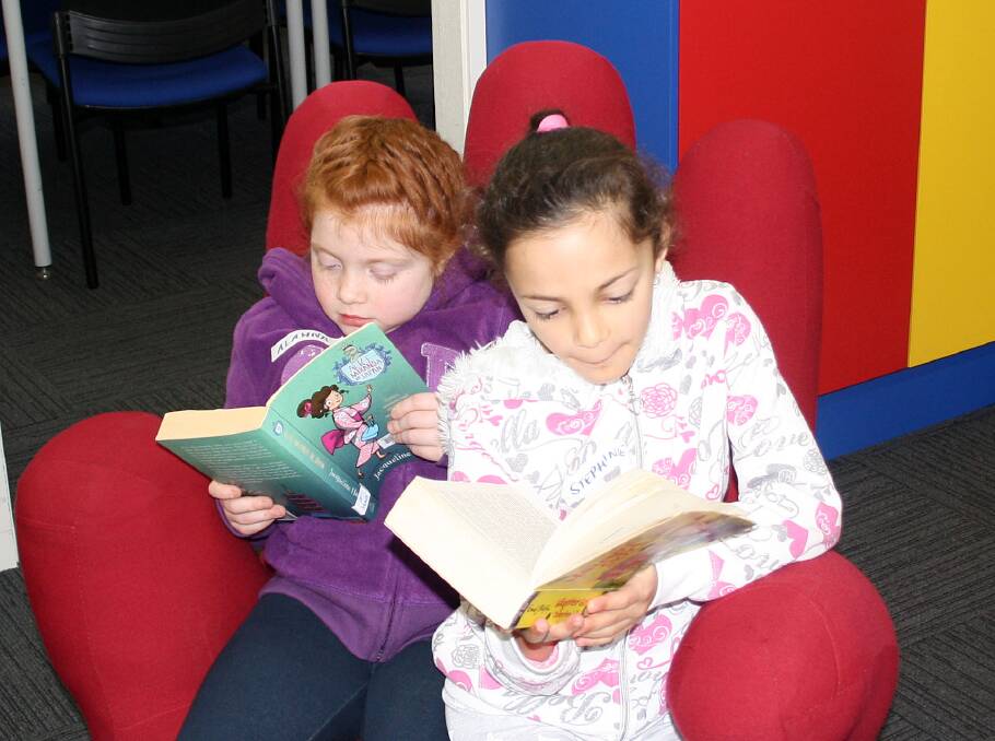 MidCoast Libraries: Alahna Dimmock and Stephanie Vassilo immersed in their reading. The Summer Reading Club is underway now.