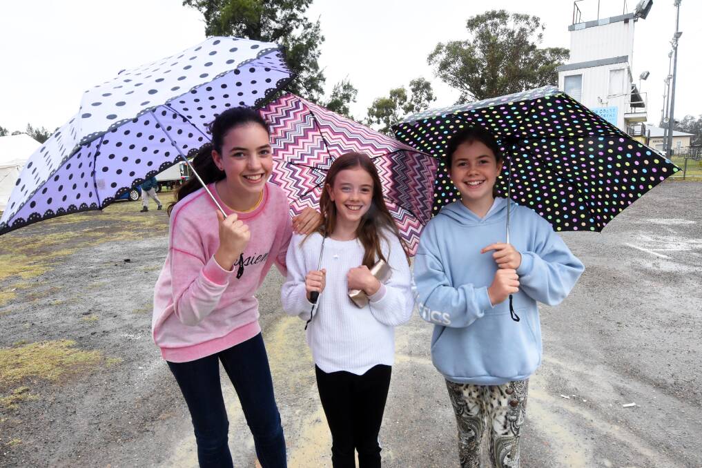 Ava, Marine and Eden Smith from Sydney take cover at the Taree Show on Friday.