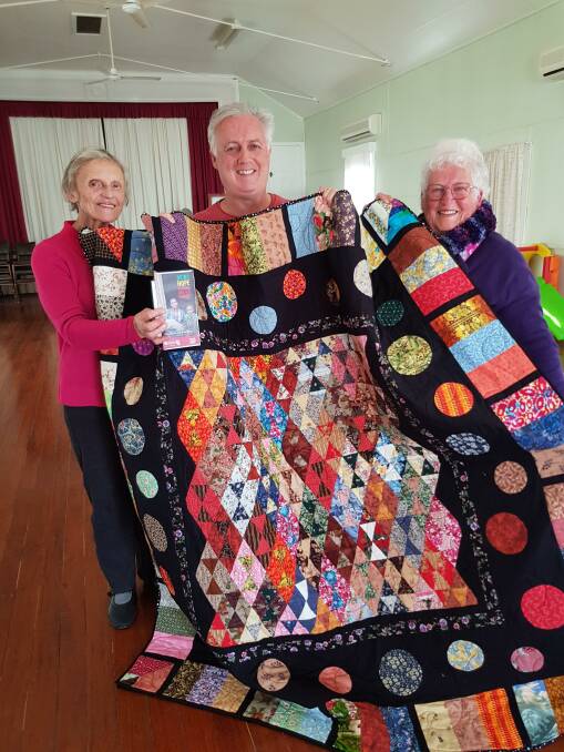 Judy Hopkins and Cath McGovern from Gloucester Patchwork Group with Cath's son David MGovern of the Catholic Mission who purchased the quilt made by his mother. Image supplied.