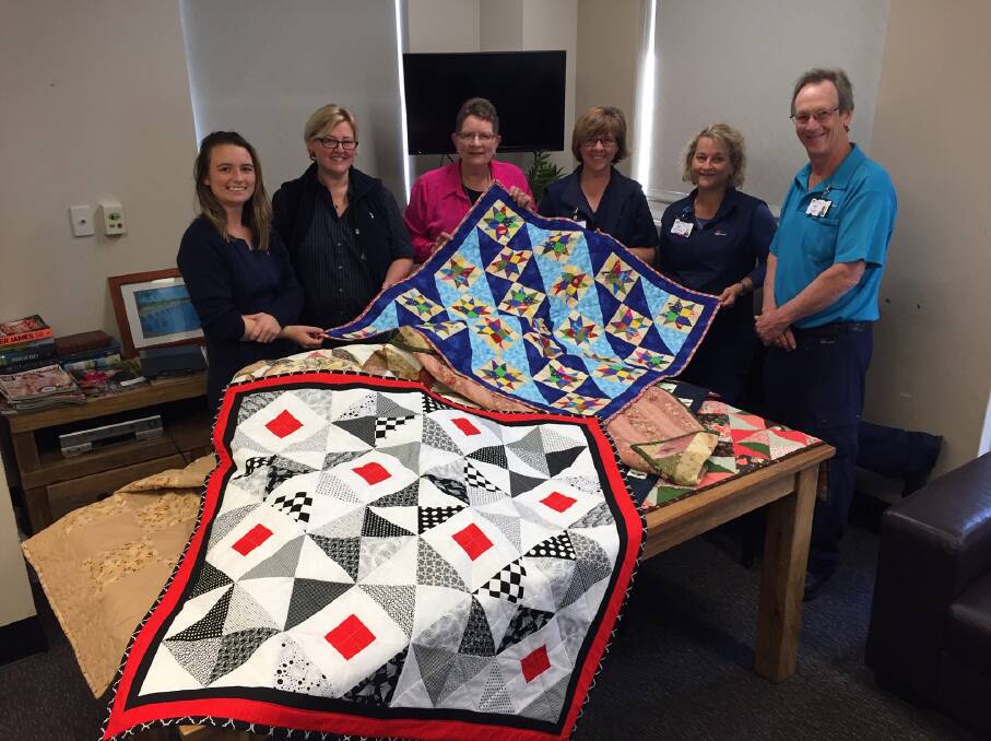 The 500th Ray of Sunshine Quilt is delivered to Manning Hospital Palliative Care Ward on Tuesday, August 27. Pictured are palliative care staff members Emma McLeod, Renae Snelgrove, Pam Eyb of Taree Craft Cottage, Sally Drury, Sarah Kerville and Phillip Blenkin.