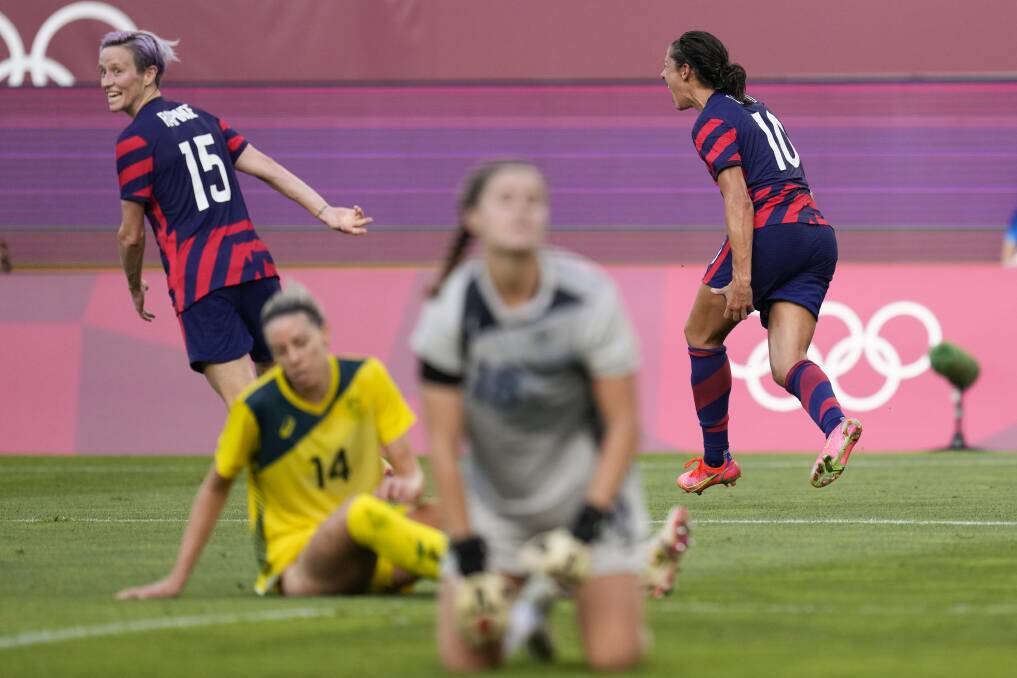 Alanna Kennedy and Teagan Micah look on in despair as the USA's Carli Lloyd celebrates scoring her side's third goal against Australia on Thursday night. Picture: AP Photo/Andre Penner