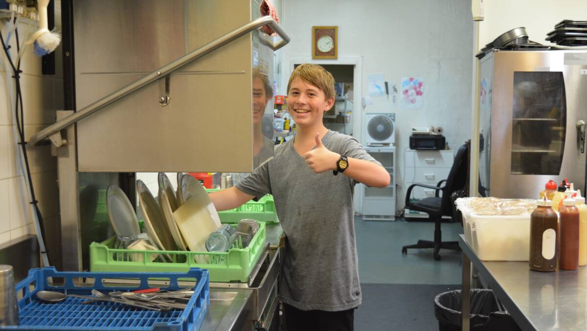 Connor Grady learns how to use an industrial dishwasher at Cafe 57. Photo Anneka Hooke