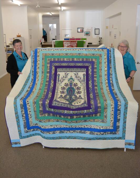 Jan Tresidder and Kim Wiesner from BWNG hold up the quilt. 