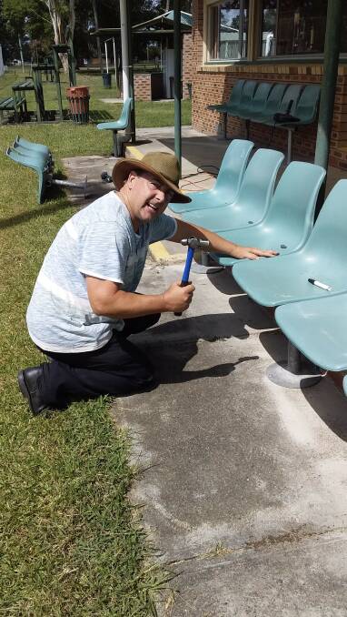 Ray Fitzgerald is busy with the installation of the new seating at the Gloucester tennis club. Photo supplied.