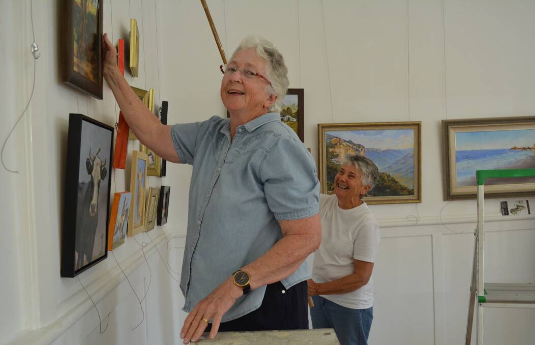 Getting ready: Maureen Clunas and Jean Spokes are busy hanging the artwork in time for the opening. Photo: Anne Keen