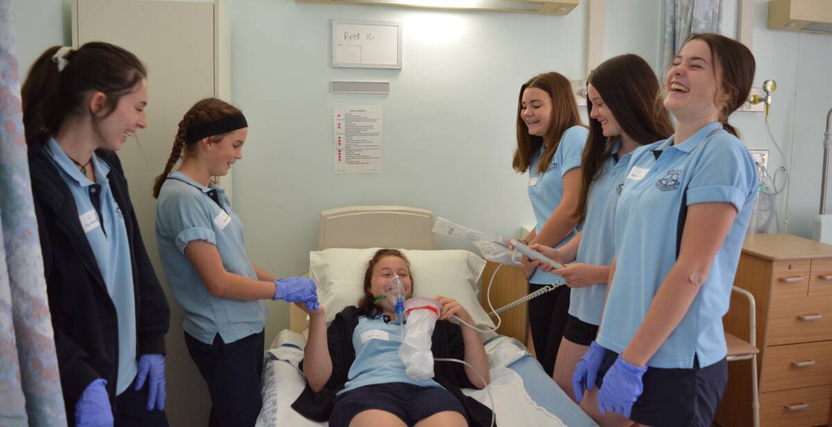 Learning nursing skills: Ella Blamires, Emily Murray, Sara McBride, Maggie Hennessy-O'Rielly and Neve O'Brien practice on Ayrleah Tull. Picture: Anne Keen