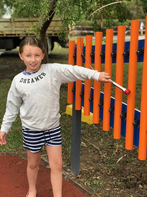 Gloucester's Hailee Labry is the first to ring the chimes in Billabong Park's newly refurbished playground. Photo supplied.