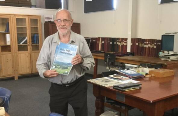Robin Budge with a copy of These Hills, These Valleys in the new archive centre attached to the Gloucester museum at 12 Church Street. Photo supplied.