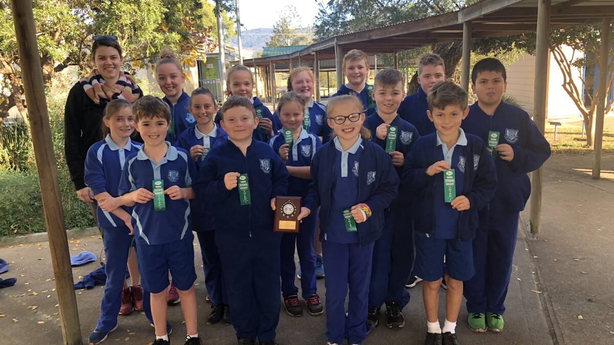 Kate Radford and the Barrington Public School choir proudly show off their Taree and District Eisteddfod trophy and ribbons. Photo supplied