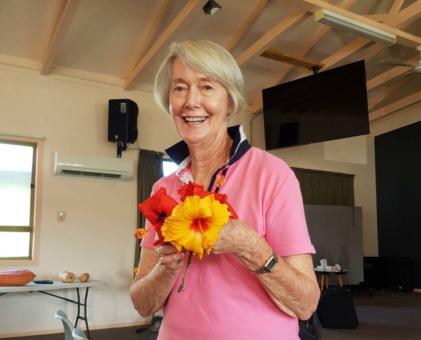Jill Carson with her lovely red and yellow hibiscus. Photo supplied