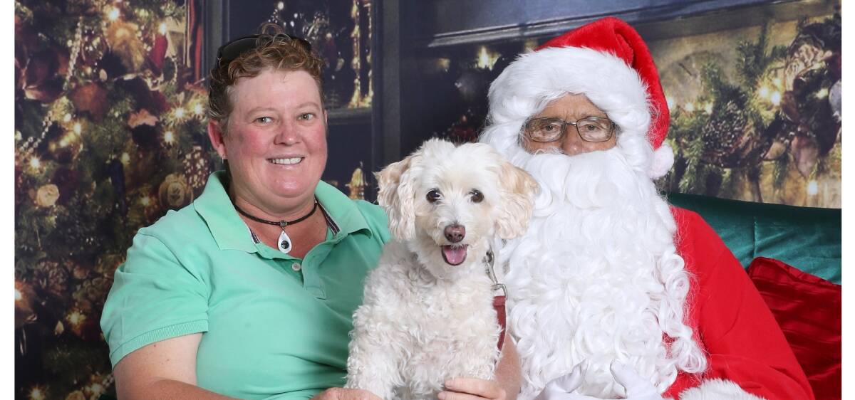 Fulfilling a childhood dream: Anne Fenning finally gets her Santa photo taken and is joined by her dog, Sandy, a Jackoodle. Picture: Sharon Benson Photography