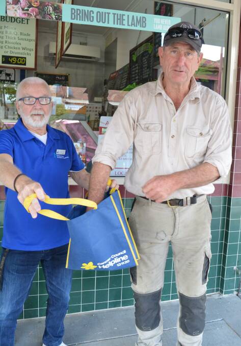 Gloucester Prostate Cancer Support Group member Robert Sparke holds the bag while Jamie Searle draws the winner of the hamper.