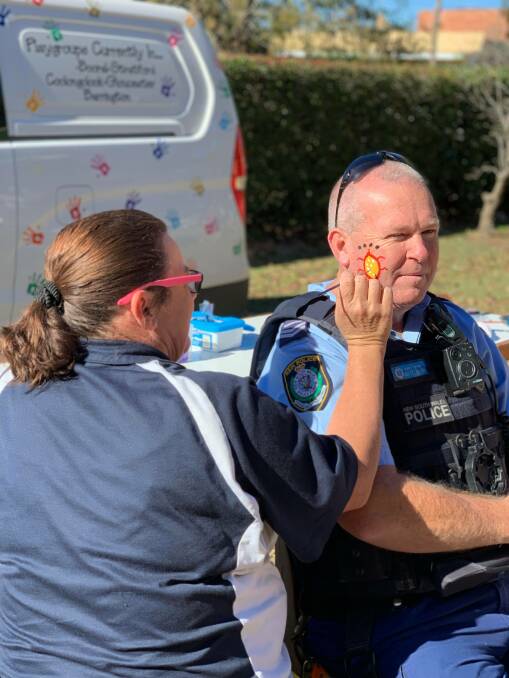 Gloucester Police Senior Constable, Scott Chester takes a moment to get his face painted at Gloucester Preschool's stall. Photo Hannah Earley