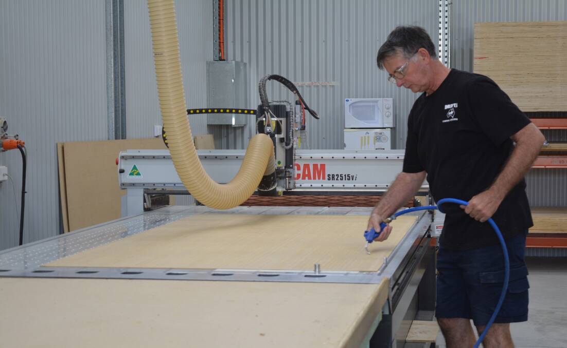 Ian Parks sets up the new C&C machine designed to cut out the plywood for the camping kitchens. Photo Anne Keen