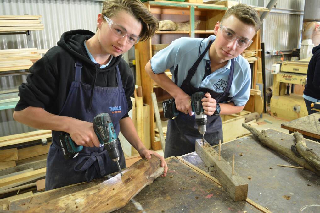 Gloucester High School year eight students Bryce Drew and Josh Norrie drill holes in their native bee hives.
