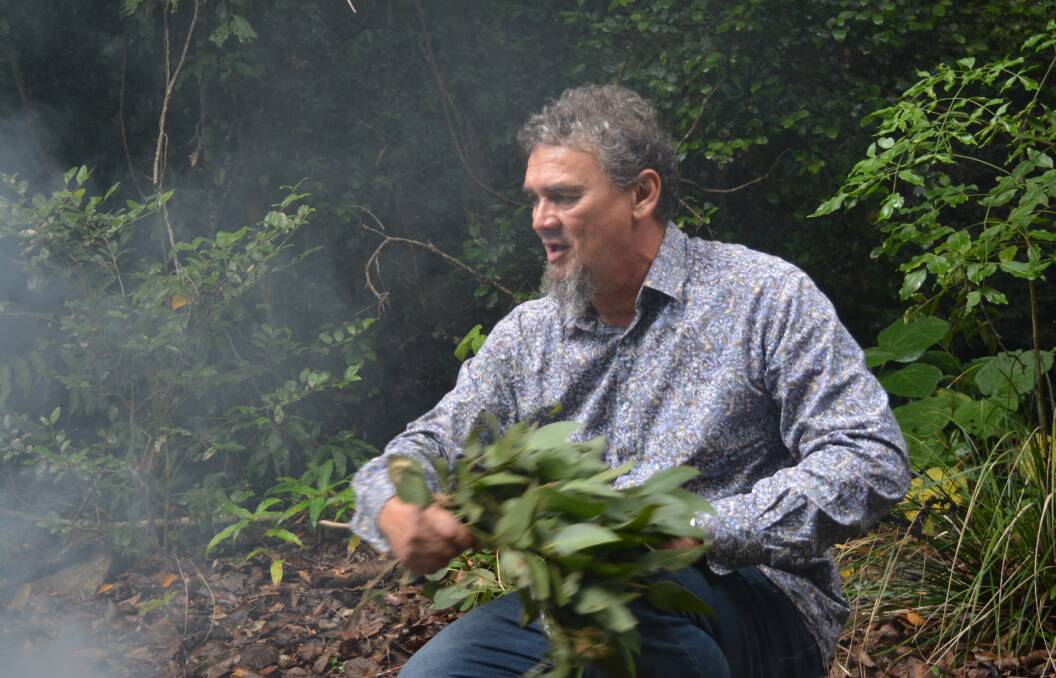 Warding off bad spirits: Steve Brereton fans the fire for the smoking ceremony during the bush tucker tour. Photo Anne Keen