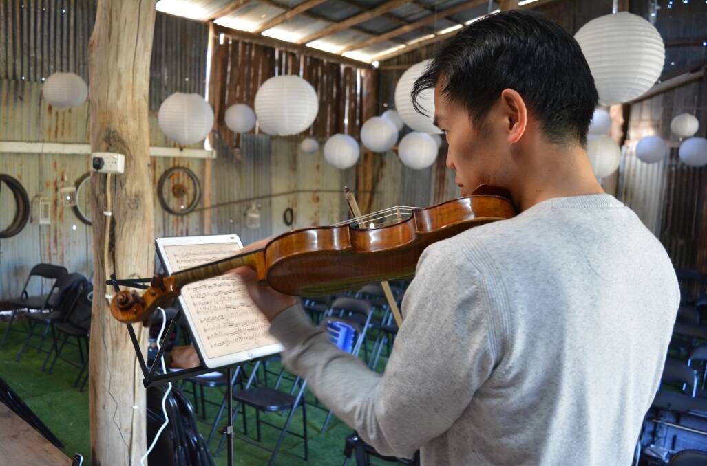 Australian Chamber Orchestra musician, Ike See warms up his voilin. 