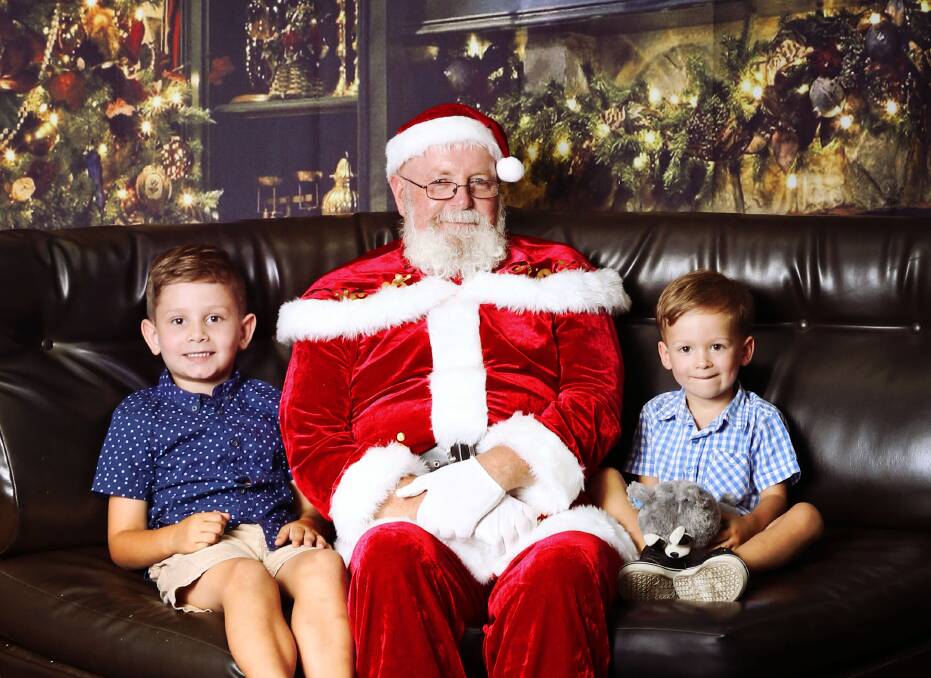Merry Christmas: Rory and Remi Ashby get their photo taken with the man in red. Photo Sharon Benson Photography