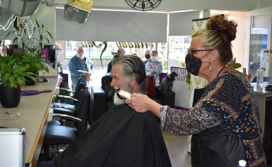 Paula Standen from Milady Salon prepares to shave away Ian's long locks and Santa beard. Photo supplied